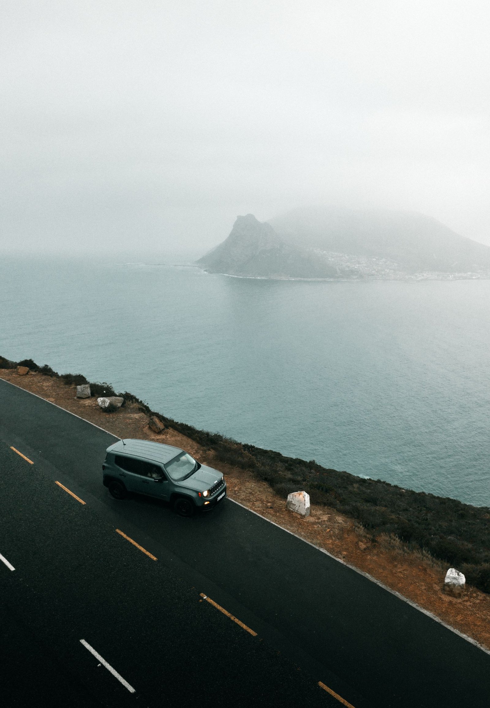 SUV travelling along a misty Cape Town coastal road