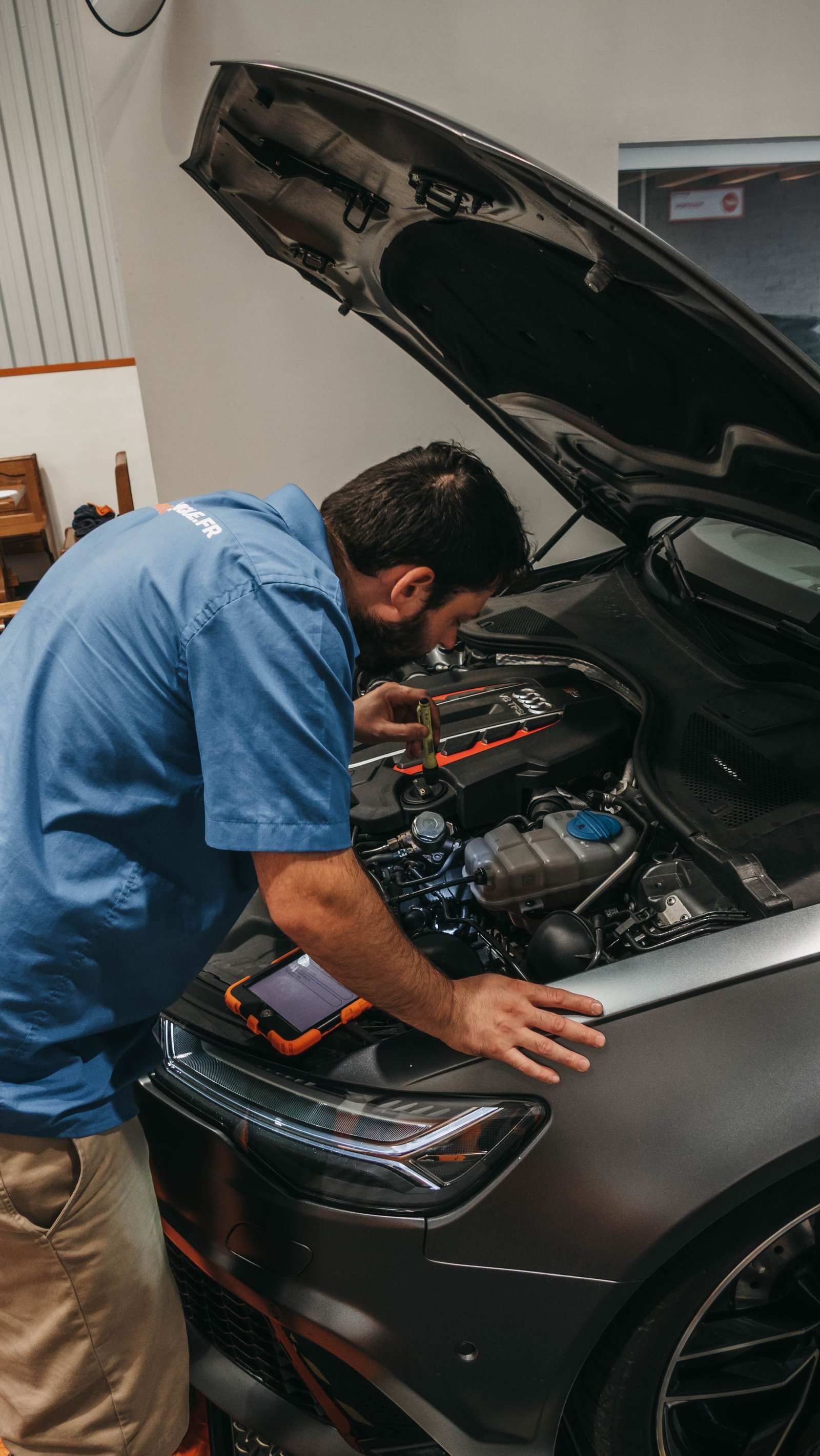 Technician inspecting a vehicle engine during a service