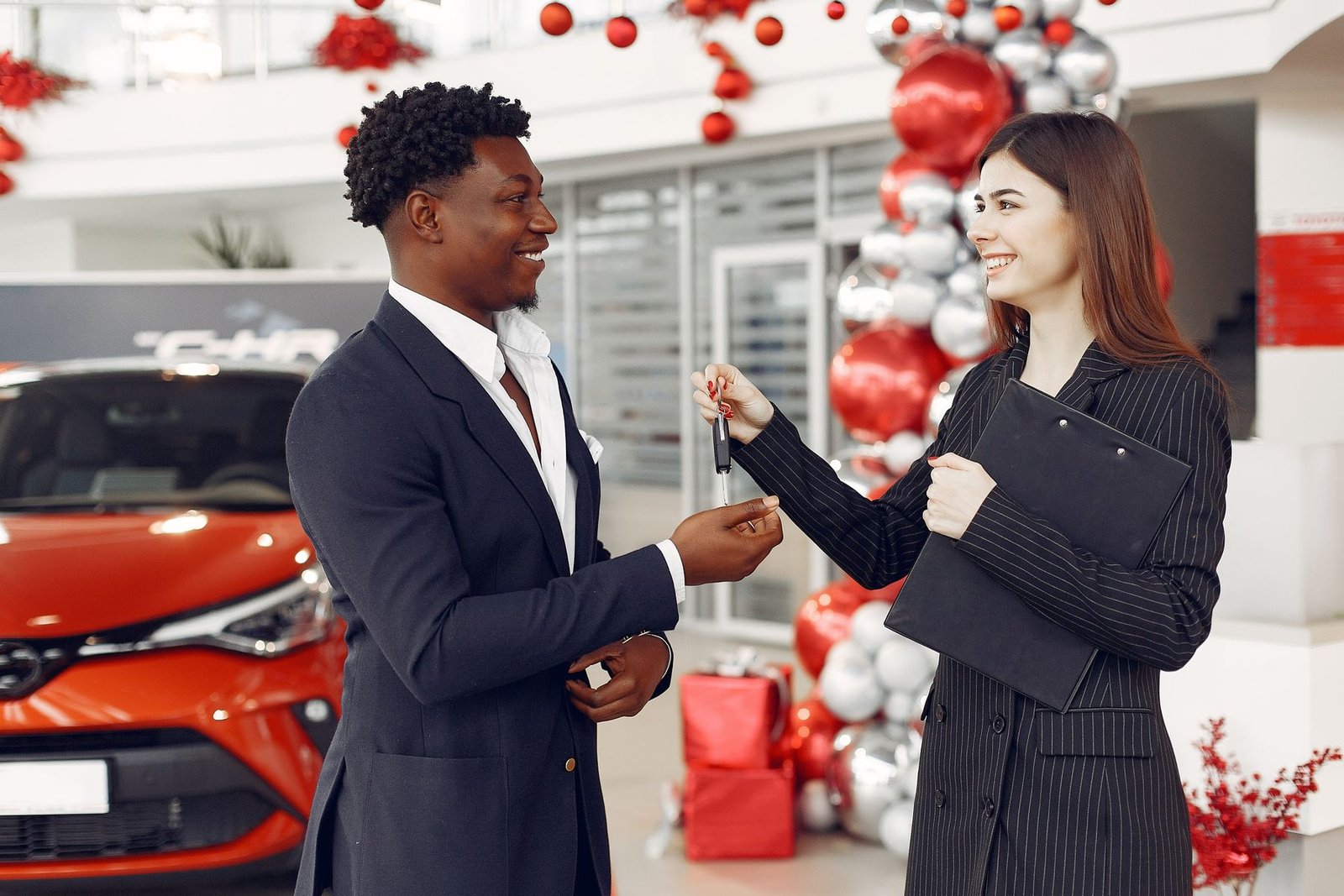 Dealership advisor handing vehicle keys to a customer